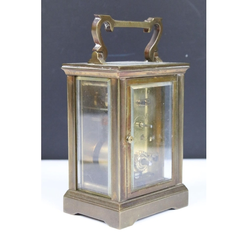 303 - Two vintage brass cased carriage clocks with beveled glass panels and white enamel dials.