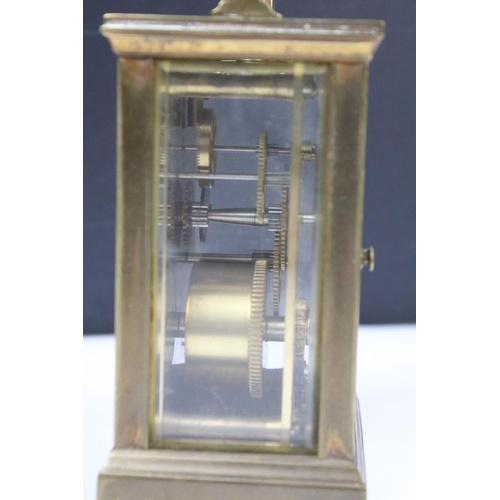 303 - Two vintage brass cased carriage clocks with beveled glass panels and white enamel dials.