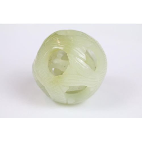 309 - Jade Puzzle Ball carved with a fish design comprising three layers plus a central ball, 6cm wide, on... 