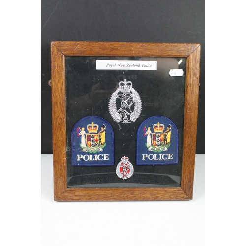 337 - A framed group of Royal New Zealand Police badges together with two police signs.