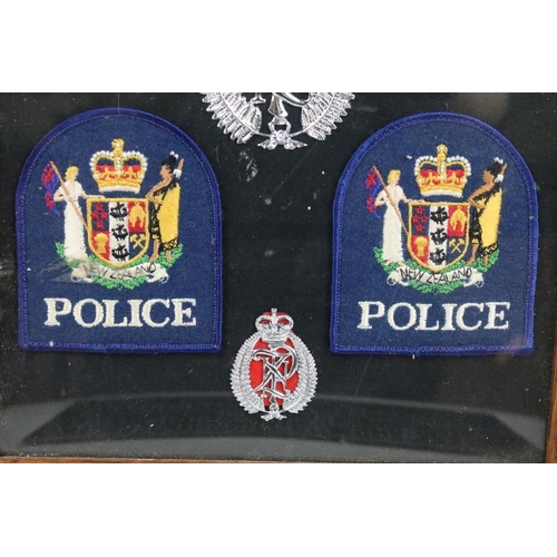 337 - A framed group of Royal New Zealand Police badges together with two police signs.