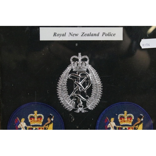 337 - A framed group of Royal New Zealand Police badges together with two police signs.