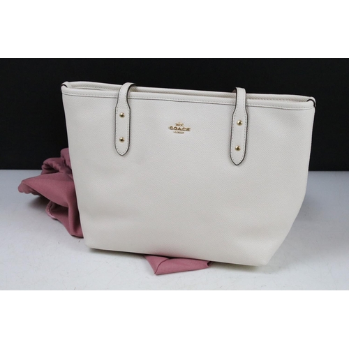 394 - Two Radley handbags to include a black leather handbag and a pink example, both housed within pink R... 