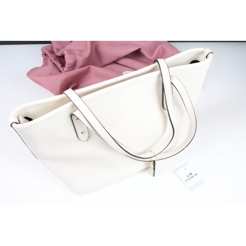 394 - Two Radley handbags to include a black leather handbag and a pink example, both housed within pink R... 