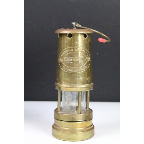 401 - Group of four brass miners lamps to include E. Thomas & Williams Ltd, Ferndale Mining Co., etc (tall... 