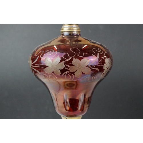 121 - Red flash glass table lamp with grape vine decoration, raised on a stepped glass base, together with... 