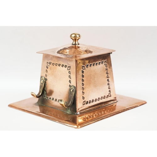 197 - Arts and Crafts Copper Square Inkwell, the hinged lid opening to a ceramic inkwell, pen hooks to sid... 