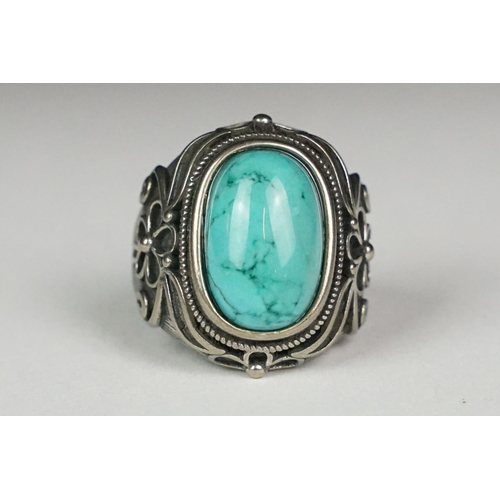 222 - A silver ladies dress ring with central turquoise cabochon and floral decoration, marked 925 to the ... 