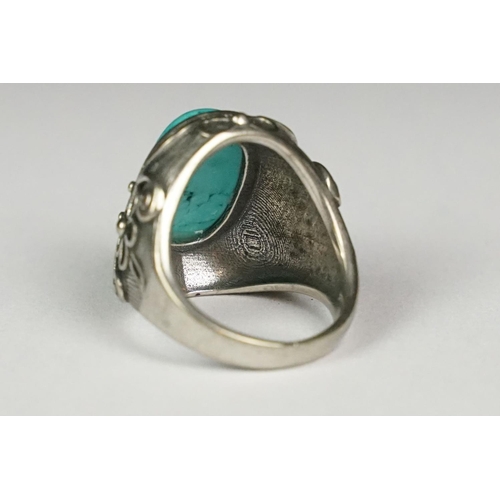 222 - A silver ladies dress ring with central turquoise cabochon and floral decoration, marked 925 to the ... 