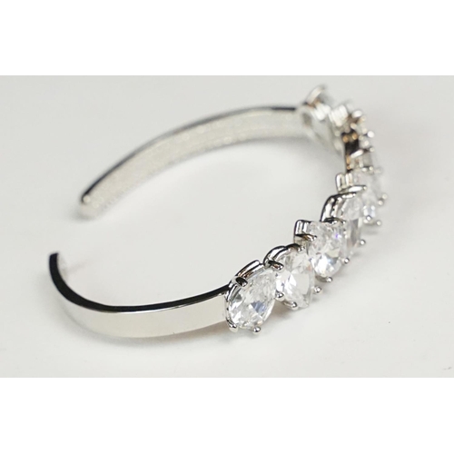 272 - A ladies silver open ended cuff bangle set with nine clear teardrop stones, marked 925 to the verso