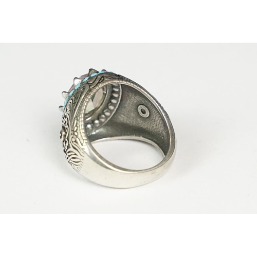 275 - A ladies silver dress ring with large central stone surrounded by turquoise, marked 925 to the inner... 