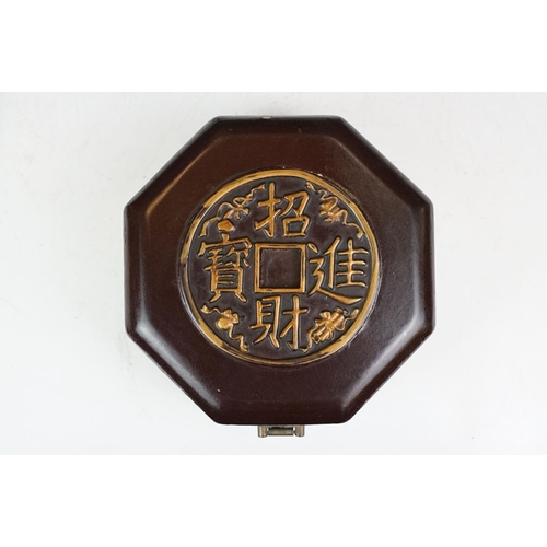 131 - Chinese octagonal wooden box with coin decoration to lid, together with a two-tiered woven lidded ca... 