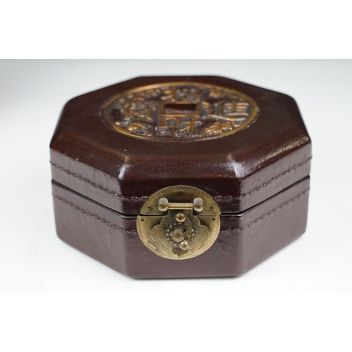 131 - Chinese octagonal wooden box with coin decoration to lid, together with a two-tiered woven lidded ca... 