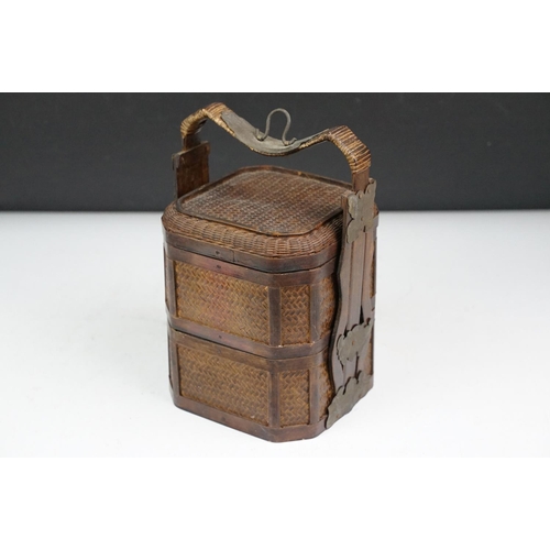 131 - Chinese octagonal wooden box with coin decoration to lid, together with a two-tiered woven lidded ca... 