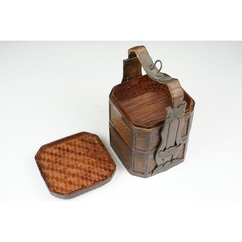 131 - Chinese octagonal wooden box with coin decoration to lid, together with a two-tiered woven lidded ca... 