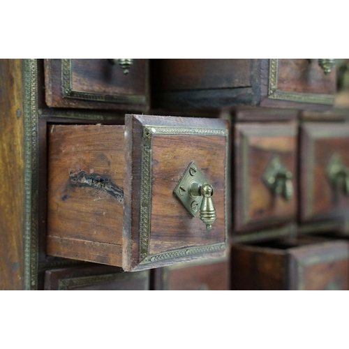 151 - Indian wooden table top cabinet / spice cabinet, the twenty drawers with brass handles and brass dec... 