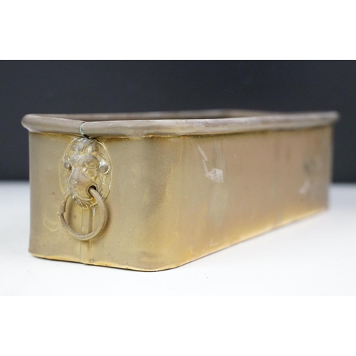 153 - Brass planter of rectangular form with twin lion mask loop handles and rolled upper rim, approx 29cm... 