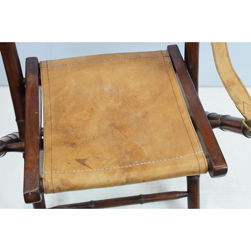 659 - 20th century mahogany campaign style chair, the frame carved to simulate bamboo with tan leather, se... 