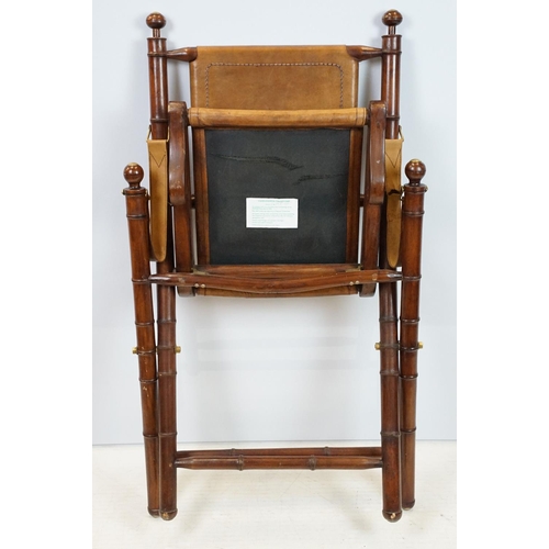 659 - 20th century mahogany campaign style chair, the frame carved to simulate bamboo with tan leather, se... 