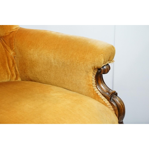 661 - Victorian mahogany carved armchair, upholstered in mustard with button back, on carved cabriole legs... 