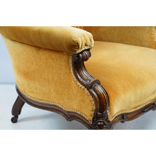 661 - Victorian mahogany carved armchair, upholstered in mustard with button back, on carved cabriole legs... 