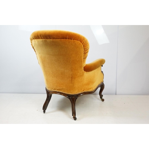 661 - Victorian mahogany carved armchair, upholstered in mustard with button back, on carved cabriole legs... 