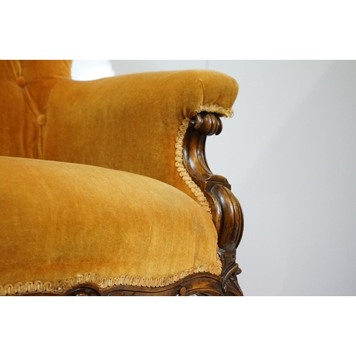 661 - Victorian mahogany carved armchair, upholstered in mustard with button back, on carved cabriole legs... 