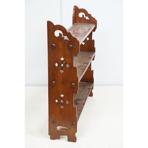 669 - Early 20th century mahogany three tier hanging shelf, each end carved with a stylised floral design,... 