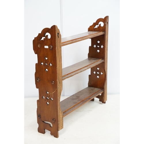 669 - Early 20th century mahogany three tier hanging shelf, each end carved with a stylised floral design,... 