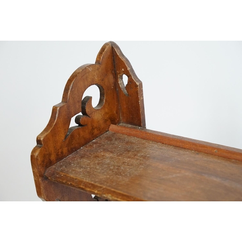 669 - Early 20th century mahogany three tier hanging shelf, each end carved with a stylised floral design,... 