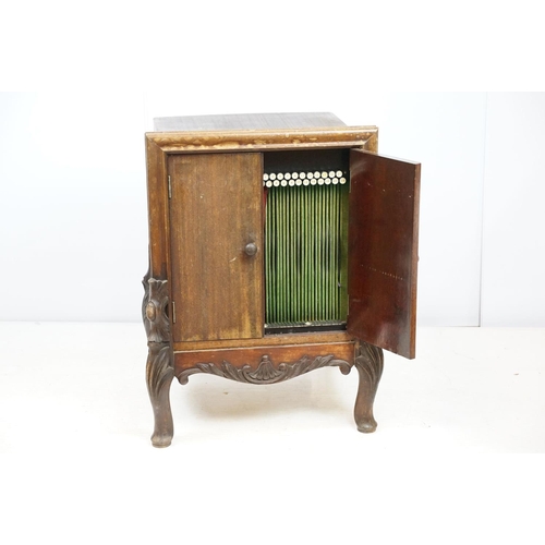 671 - Continental carved record storage cabinet, with ejector buttons, holding a number of 78s, 68cm high ... 