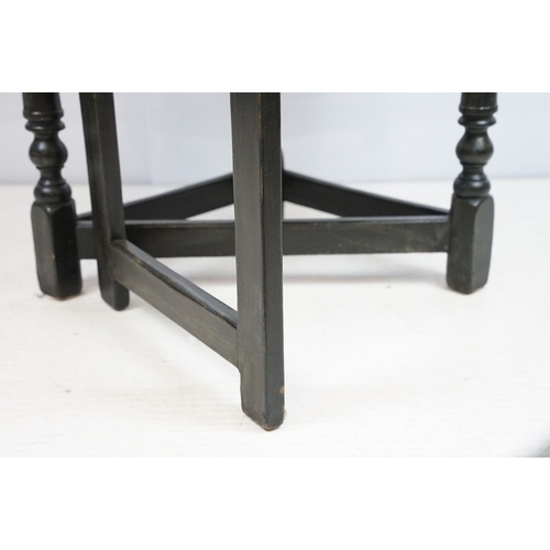 700 - Carved oak drop leaf table, black painted, 58cm high x 67cm diameter