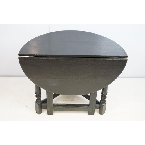 700 - Carved oak drop leaf table, black painted, 58cm high x 67cm diameter