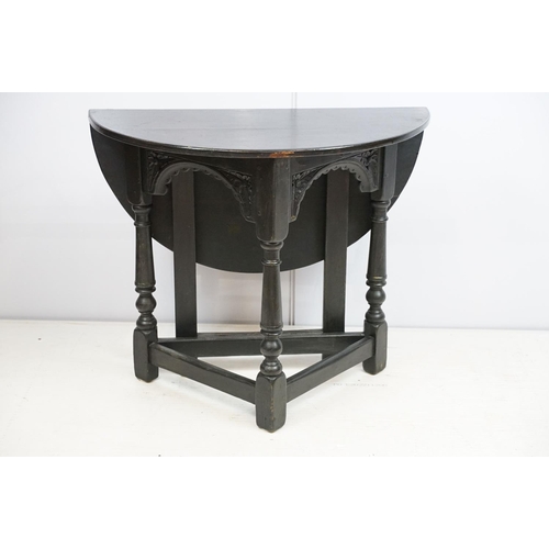 700 - Carved oak drop leaf table, black painted, 58cm high x 67cm diameter