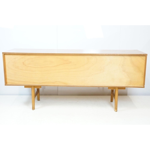 712 - Avalon teak sideboard with an arrangement of three drawers and two sliding cupboard doors, maker's l... 