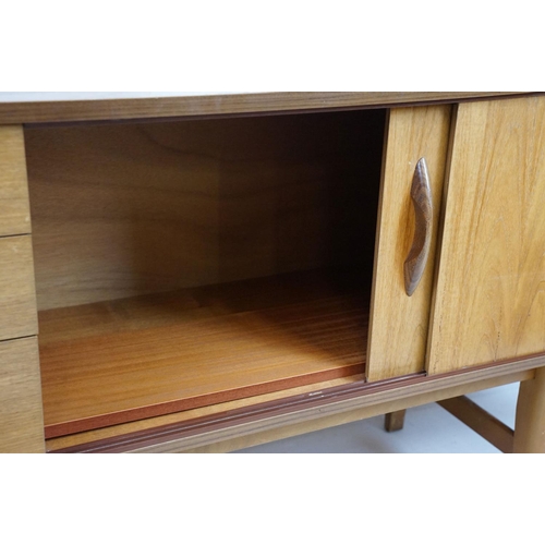 712 - Avalon teak sideboard with an arrangement of three drawers and two sliding cupboard doors, maker's l... 