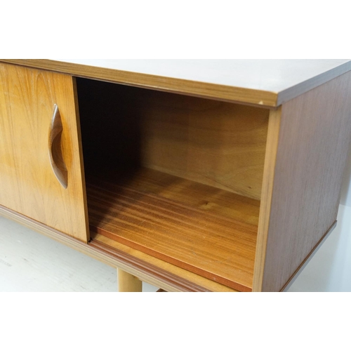 712 - Avalon teak sideboard with an arrangement of three drawers and two sliding cupboard doors, maker's l... 