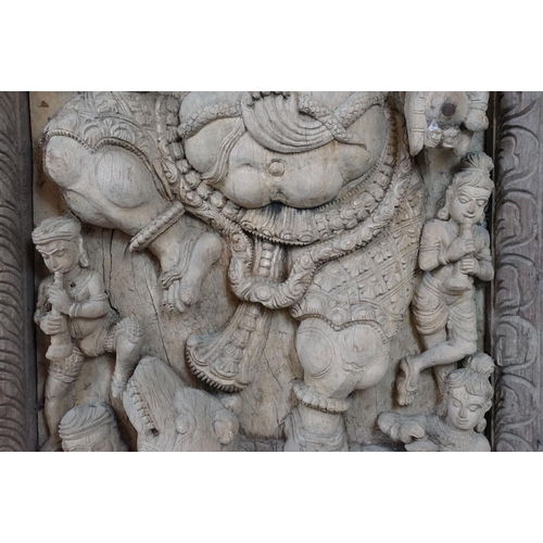 755 - Pair of large Indian carved wooden panels depicting Ganesh surrounded by various figures, each measu... 