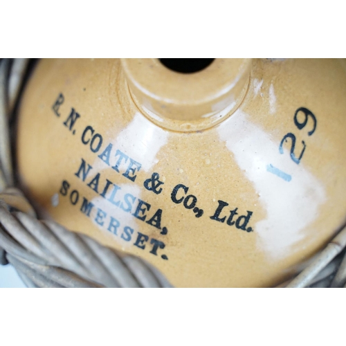 73 - R.N. Coate & Co Ltd of Nailsea, Somerset - A stoneware cider flagon housed within a wicker carrier, ... 