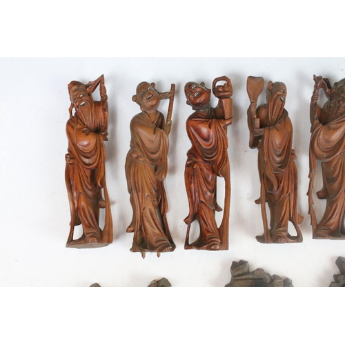 218 - A collection of Chinese carved wooden figures with wooden bases.