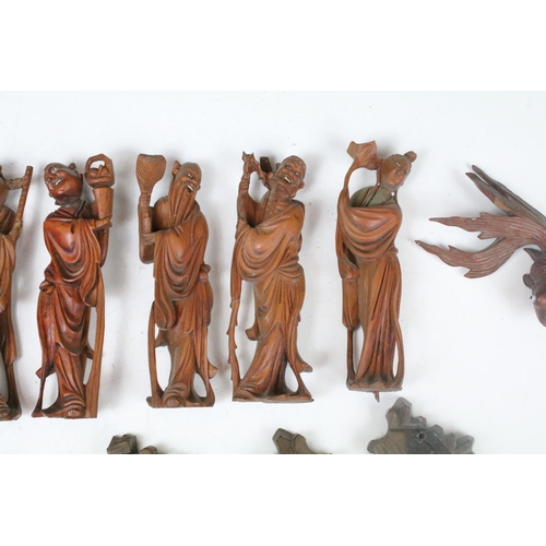 218 - A collection of Chinese carved wooden figures with wooden bases.