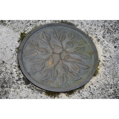 626 - Reconstituted stone round top garden table with metal plaque to centre, raised upon a support with r... 