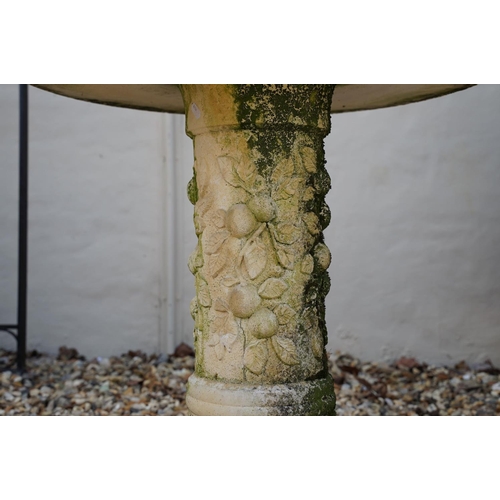 626 - Reconstituted stone round top garden table with metal plaque to centre, raised upon a support with r... 