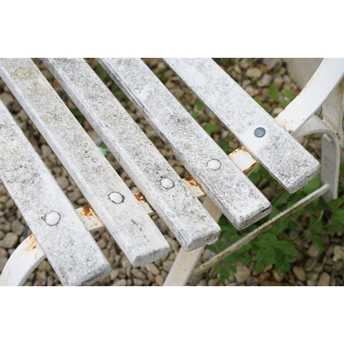 638 - White painted slatted garden bench raised on three wrought iron supports, approx 152cm wide