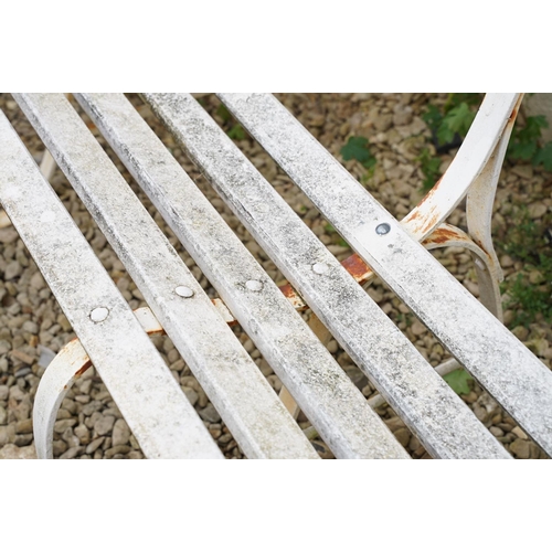 638 - White painted slatted garden bench raised on three wrought iron supports, approx 152cm wide