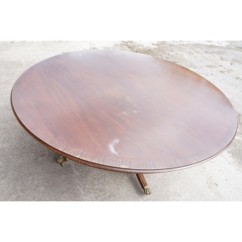 644 - Large circular mahogany dining table with veneer to edge, raised on a five-footed base with casters,... 