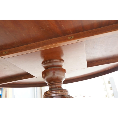 644 - Large circular mahogany dining table with veneer to edge, raised on a five-footed base with casters,... 