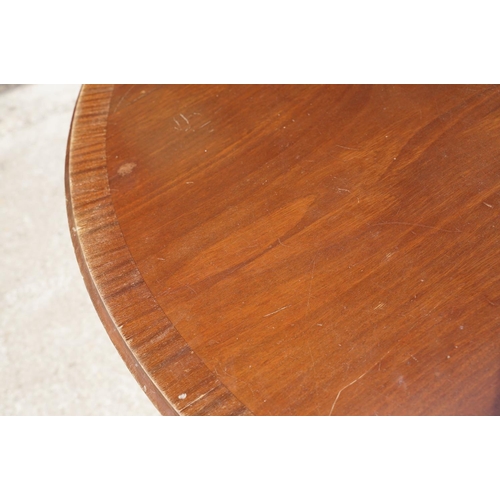 644 - Large circular mahogany dining table with veneer to edge, raised on a five-footed base with casters,... 