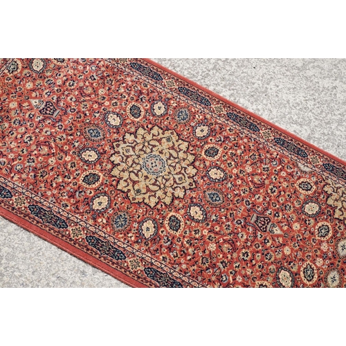 765 - Super Keshan hand-made red ground carpet / runner of geometric design, approximately 350 x 90cm