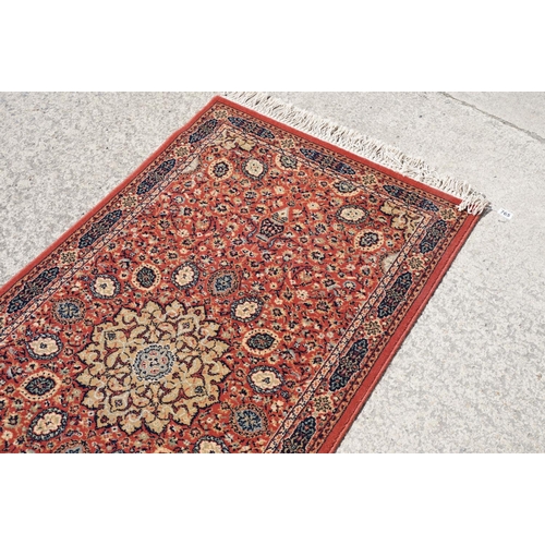 765 - Super Keshan hand-made red ground carpet / runner of geometric design, approximately 350 x 90cm